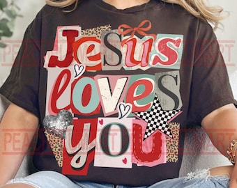 May include: Dark brown t-shirt with the text "Jesus Loves You" in a collage style. The design includes hearts, a checkered star, and leopard print accents in red, pink, and silver. The shirt is a relaxed fit.