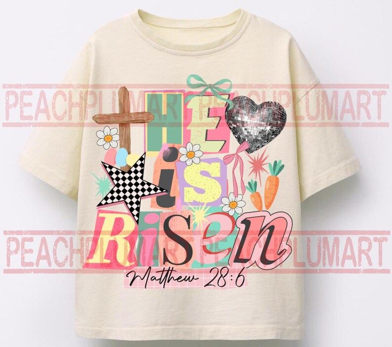May include: Cream-colored t-shirt with a colorful graphic design. The design includes the words "He is Risen" in various colors, a cross, a star, a heart, carrots, and daisies. The text "Matthew 28:6" is also included.
