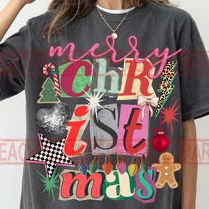 May include: Dark gray t-shirt with a colorful Christmas design. The design includes the words "merry Christmas" in a collage style with festive elements like a gingerbread man, Christmas tree, and ornaments.