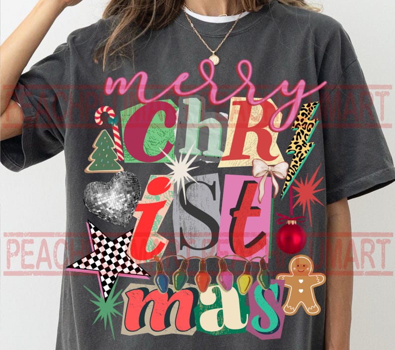 May include: Dark gray t-shirt with a colorful Christmas design. The design includes the words "merry Christmas" in a collage style with festive elements like a gingerbread man, Christmas tree, and ornaments.