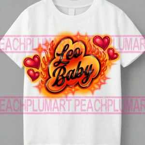 May include: White t-shirt with a colorful airbrushed design. The design features the words "Leo Baby" in black script, surrounded by orange flames, red hearts, and starbursts. A fun and vibrant graphic tee.