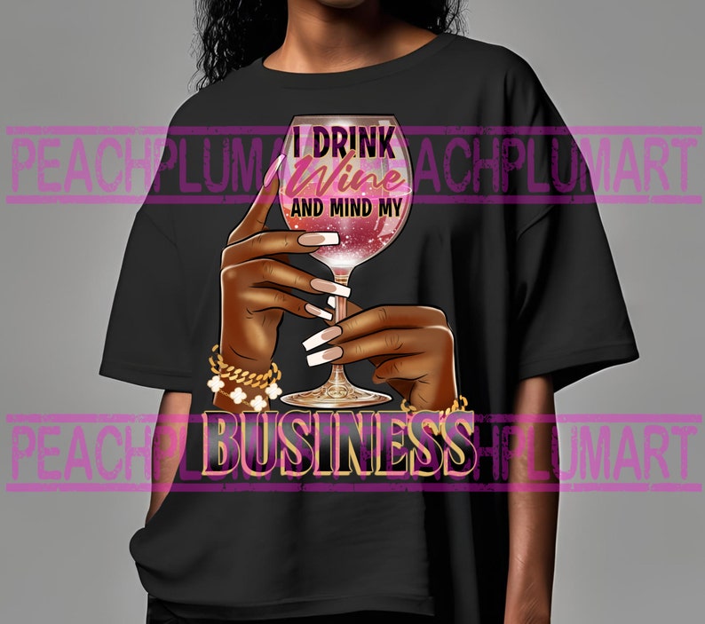 May include: Black t-shirt with the text "I drink wine and mind my business" in pink and gold lettering. A hand holding a glass of wine is depicted in the center of the shirt.