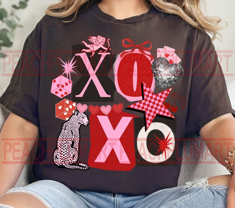 May include: Dark gray t-shirt with a Valentine's Day graphic. The design includes the letters "XO", a leopard, hearts, dice, a star, and a cupid. The colors are red, pink, and black.