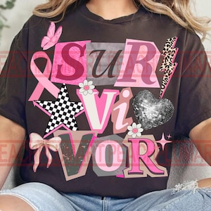 May include: Dark brown t-shirt with the word "SURVIVOR" in pink, white, and gray block letters. The design includes a pink ribbon, a butterfly, a star, a bow, a disco ball heart, and a lightning bolt.