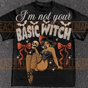 May include: Black t-shirt featuring the text "I'm not your BASIC WITCH" and a graphic of a witch holding a skull. The witch is wearing a black corset, fishnet stockings, and a witch hat. Two orange bows and bats are also featured.