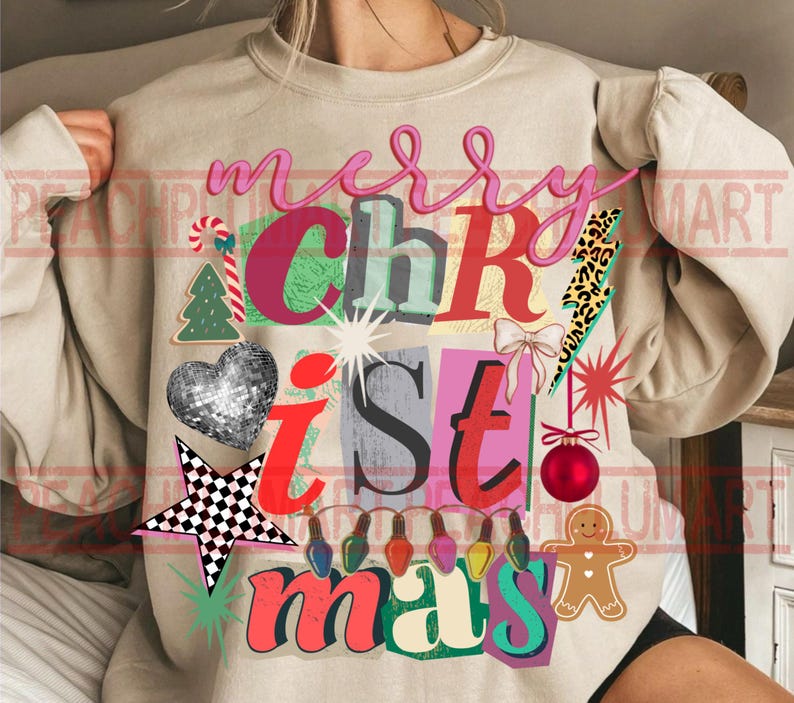 May include: Beige sweatshirt with a colorful "Merry Christmas" graphic. The design includes a disco ball heart, star, Christmas tree, gingerbread man, and other festive elements. The text is in various fonts and colors.