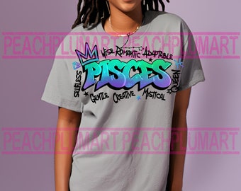 May include: A gray t-shirt with a colorful graphic design of the word "Pisces" in graffiti style. The design includes a crown, a diamond, and the words "Wise Romantic Adaptable", "Selfless", "Gentle Creative Mystical", and "Queen".