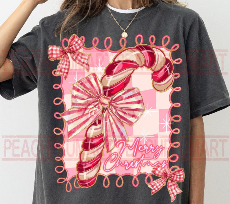 May include: Dark gray t-shirt featuring a candy cane design with red and white stripes, adorned with bows and the text "Merry Christmas." The design is set against a pink checkered background, creating a festive holiday theme.