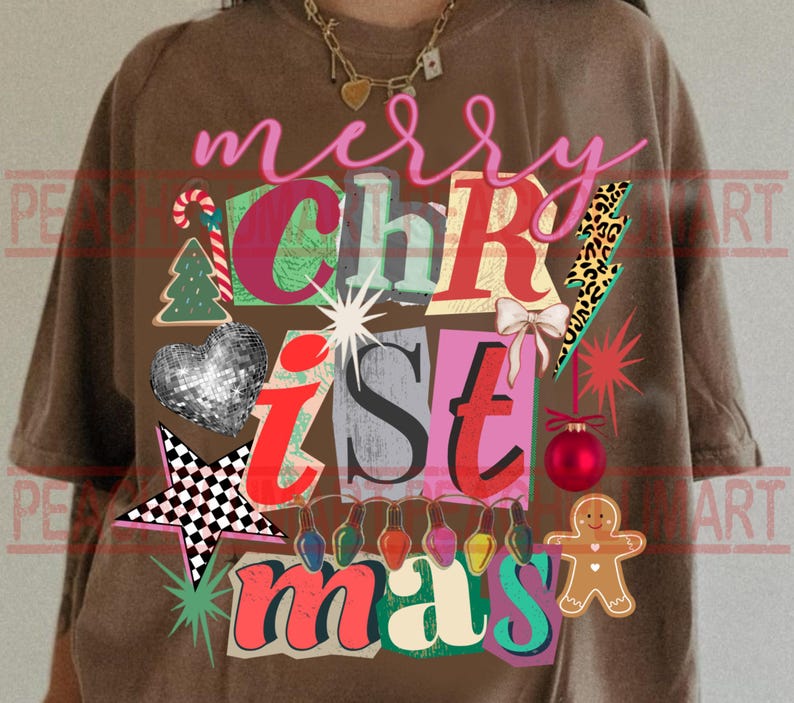 May include: Brown t-shirt with a colorful "Merry Christmas" graphic. The design includes a Christmas tree, heart, star, and gingerbread man. The text is in a mix of fonts and colors, with a festive holiday theme.