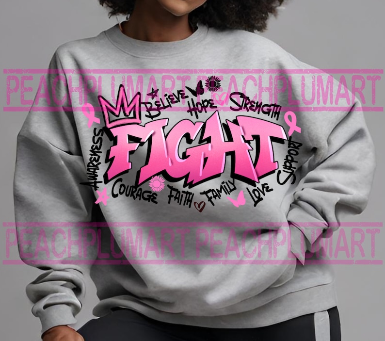 Op de afbeelding: Grijs sweatshirt met een roze grafisch ontwerp met de tekst "FIGHT" in grote letters. De grafiek bevat ook de woorden "awareness", "believe", "hope", "strength", "courage", "faith", "family", "love" en "support".