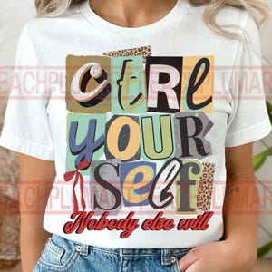 Puede incluir: Camiseta blanca con el texto "CTRL YOUR SELF Nobody else will" en un estilo collage. El texto está en varios colores y fuentes, con un lazo rojo. La camiseta está hecha de un material suave.