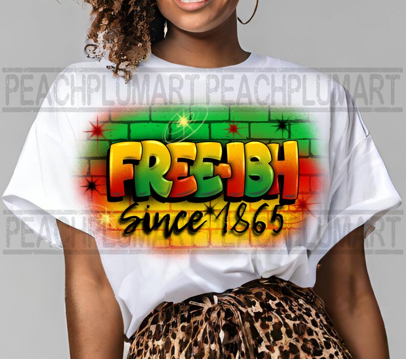 May include: White t-shirt with a graphic design of the words "Free-ish" in a graffiti style with a brick wall background and the text "Since 1865".