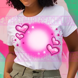 Pu&ograve; includere: Maglietta bianca con un design a spruzzo rosa di cuori e stelle. I cuori sono rosa e hanno una finitura lucida.