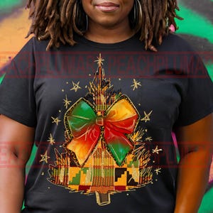 May include: Black t-shirt with a colorful Christmas tree design. The tree is made of a patterned fabric with a large bow on top. The bow is red, yellow, and green.