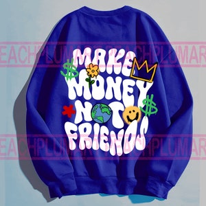 May include: A royal blue sweatshirt with a white graphic that says "Make Money Not Friends" in a retro font. The graphic also includes a crown, a flower, a smiley face, a dollar sign, and a globe.