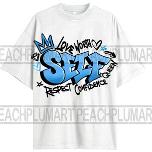 May include: White t-shirt with a blue and black graphic design that says "SELF" with the words "Love Worth", "Respect", "Confidence", and "Queen" surrounding the word "SELF".