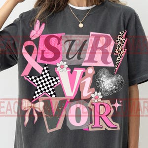 May include: Dark gray t-shirt with the word "Survivor" in pink, white, and black letters. The design includes a pink ribbon, a butterfly, a star, a bow, a disco ball heart, and a lightning bolt.