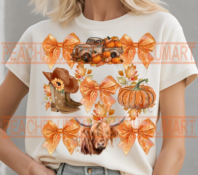 May include: A white t-shirt with a fall-themed design featuring a truck carrying pumpkins, a cow, cowboy boots, and orange bows. The design is surrounded by fall leaves.