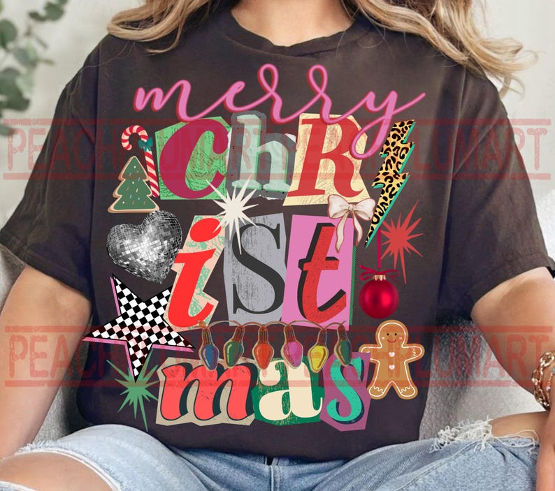 May include: Dark brown t-shirt with a colorful Christmas graphic. The design includes the words "merry Christmas" in pink and various festive elements like a candy cane, Christmas tree, and gingerbread man.