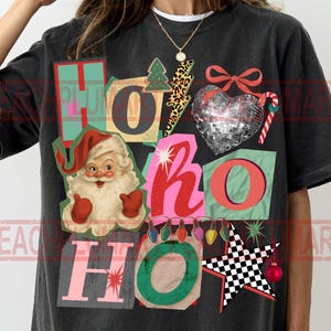 Könnte beinhalten: Schwarzes T-Shirt mit einem farbenfrohen Weihnachtsmotiv. Das Design umfasst eine Illustration des Weihnachtsmanns, ein Herz aus Discokugeln und die Worte "HO HO HO" in verschiedenen Schriftarten und Farben. Festlich und lustig.