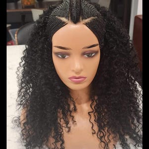 May include: A black wig with curly hair, styled with cornrows and a middle part. The wig is on a mannequin head.