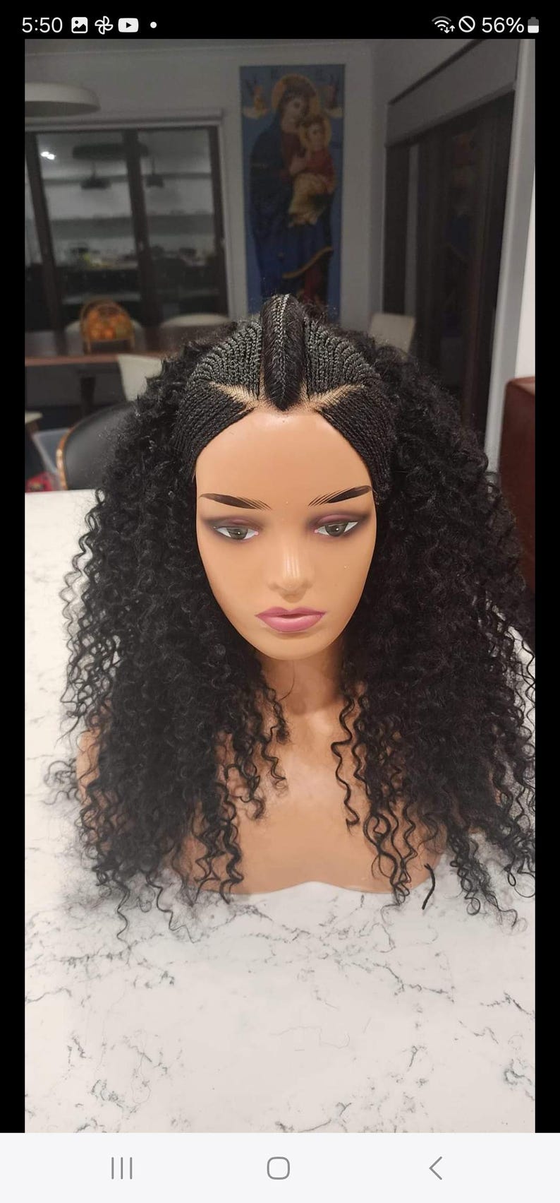 May include: A black wig with curly hair, styled with cornrows and a middle part. The wig is on a mannequin head.