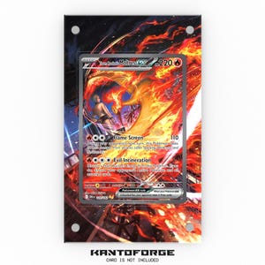 May include: A framed Pokémon card featuring Moltres EX with a fiery background. The card displays the text "Team Rocket Moltres EX" and "Flame Screen". The frame is black with silver screw heads. The text "KANTOFORGE" is at the bottom.