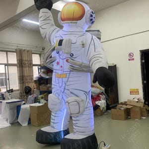 Op de afbeelding: Een opblaasbare astronautfiguur, voornamelijk wit met zwarte accenten, heft een arm op. De helm heeft een gouden vizier en het pak heeft blauwe verlichting. De afbeelding bevat de tekst 'LAY-Z-DAYS EVENTS'.