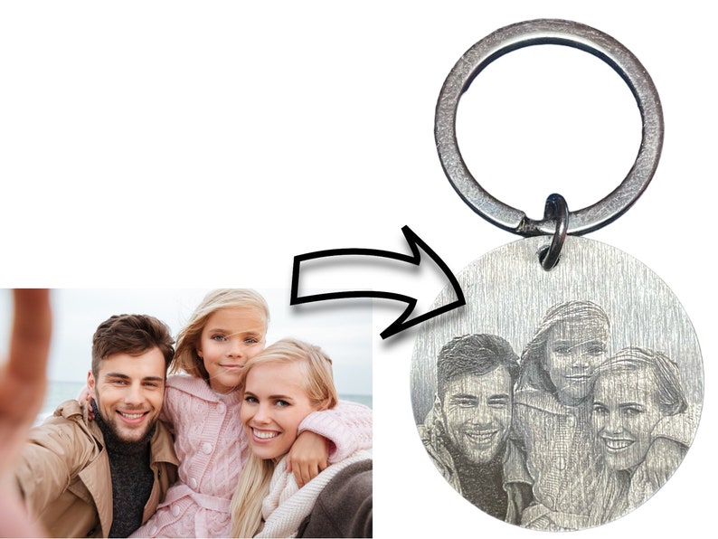 May include: A silver keychain with a round metal charm featuring a black and white engraved photo of a family of four. The keychain has a silver ring.