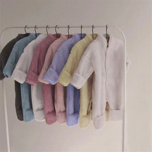Bright Spring Jumpsuits For Newborns Hang On Hangers In A