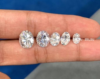 May include: Five round, clear, brilliant cut gemstones of varying sizes, arranged in a row from largest to smallest, on a finger.