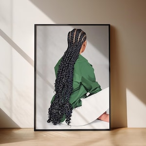 Könnte beinhalten: Ein gerahmter Kunstdruck mit einer Person mit langen, dunklen Zöpfen, die eine grüne Jacke und eine weiße Hose trägt. Das Kunstwerk ist vor einem neutralen Hintergrund mit einem schwarzen Rahmen platziert. Das Bild wird von natürlichem Licht beleuchtet.