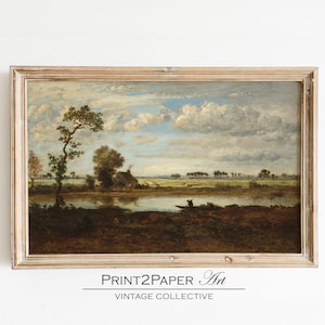 Peut inclure: Peinture de paysage vintage encadrée, représentant une scène de rivière paisible sous un ciel nuageux. L'œuvre montre une petite maison, des arbres et une silhouette dans un bateau. Le cadre est en bois clair vieilli. Le texte "PRINT2PAPER Art VINTAGE COLLECTIVE" est en bas.