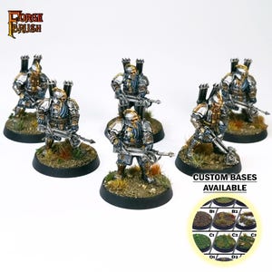 May include: Six miniature figures of warriors with crossbows, painted in silver and gold, standing on round bases with green and brown textured surfaces. The text "CUSTOM BASES AVAILABLE" is displayed below the figures. A circular image shows different base options.