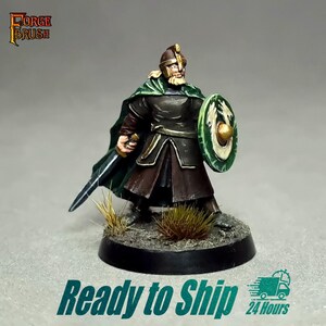 May include: A detailed miniature warrior figurine, clad in dark armour with a green cape and helmet, holding a sword and a green and gold shield. The base is black with grass. The text "Forge Brush" is visible.