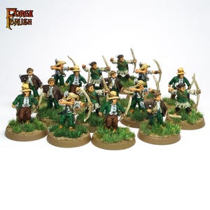 Puede incluir: Figuras en miniatura de arqueros, cada una sobre una base circular con hierba. Los arqueros visten chaquetas verdes, pantalones marrones y sombreros color beige, sosteniendo arcos y flechas. El logo "Forge Brush" es visible.
