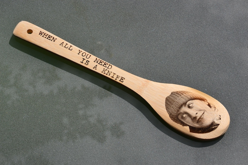 Puede incluir: Una cuchara de madera con el texto "When all you need is a knife" grabado en ella. Tambi&eacute;n hay un rostro de una persona grabado en la cuchara.