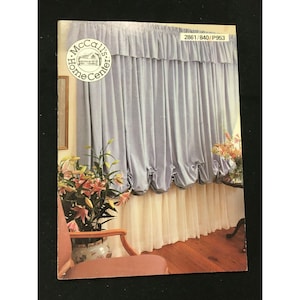 Puede incluir: Un patrón de cortinas de McCall's Home Center, que muestra una ventana con cortinas azules y blancas. El número del patrón es 2861/840/P953.