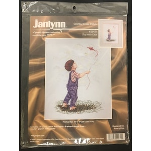 May include: Counted cross stitch pattern featuring a boy flying a kite. The pattern is titled "Boy with Kite" and is numbered #29-31. The finished size is 25.4 cm by 33.0 cm.