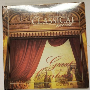 May include: A vintage CD case with a gold and red design. The case features a picture of a stage curtain with a garden scene behind it. The text on the case reads "In Classical Mood Great Overtures".