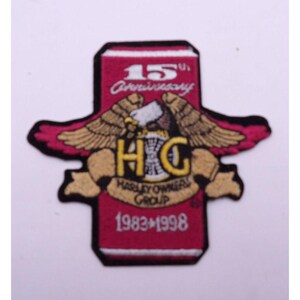 May include: Red and gold embroidered patch with an eagle and the text "H.O.G. Harley Owners Group 15th Anniversary 1983-1998"