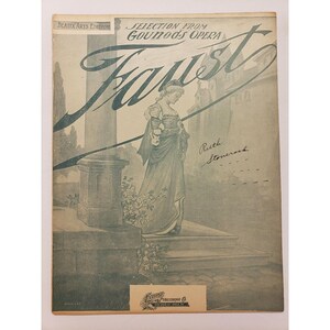 May include: Vintage sheet music cover for Gounod's opera "Faust." The cover features a sepia-toned illustration of a woman in a long gown, standing on steps. The title is in large, stylized script. The text "Beaux Arts Edition" is in the upper left corner.