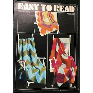 May include: A vintage knitting pattern booklet titled "Easy to Read" by Coats & Clarks. The cover features three colourful knitted blankets in a chevron, square, and diamond pattern.