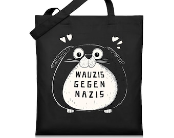 May include: Black tote bag with a white cartoon animal with the text "Wauzis gegen Nazis" on the front.