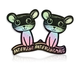 May include: Two black mouse-shaped stickers with rainbow accents and the text "ANTIFASCHISMAUS" on a curved banner. The mice have large eyes and are sitting upright. The stickers have a glossy finish.