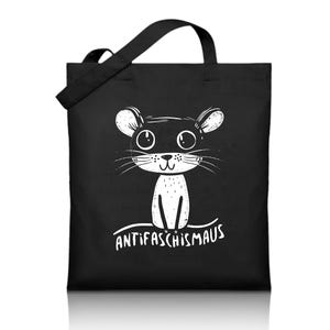 Könnte beinhalten: Schwarze Tragetasche mit einem weißen Cartoon-Maus-Design und dem Text "ANTIFASCHISMAUS". Die Maus hat große Augen und Schnurrhaare. Die Tasche hat einen einzelnen Schulterriemen und ist aus strapazierfähigem Material.