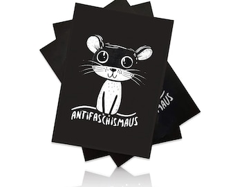 May include: A stack of black notebooks with a white cartoon mouse illustration. The mouse has a black mask and the text "ANTIFASCHISMAUS" is written in white below the mouse.