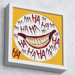 May include: A framed print with a yellow background and a white circle containing a red and white grinning mouth with the word "HA" repeated around the circle.