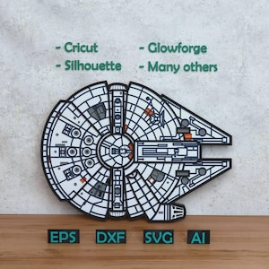 Può includere: Un design multistrato nero, bianco e grigio del Millennium Falcon. L'immagine include il testo "- Cricut - Glowforge - Silhouette - Many others" e le abbreviazioni dei tipi di file "EPS, DXF, SVG, AI". Il design è su una superficie di legno.