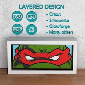 May include: A framed, layered design featuring a Teenage Mutant Ninja Turtle character with a red mask. The artwork is in a white frame, with the character's face in green, black, and red. The image also includes text and icons for SVG, EPS, DXF, and AI file formats.